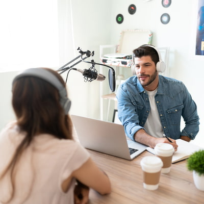 Periodista trabajando en su podcast realizando una entrevista